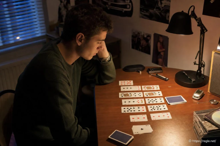 Jeune homme jouant au solitaire cartes