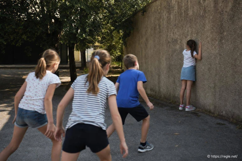 Enfants jouant à cache-cache contre un mur