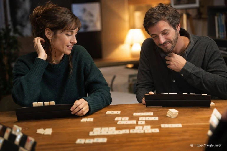 Couple jouant au rummikub à table
