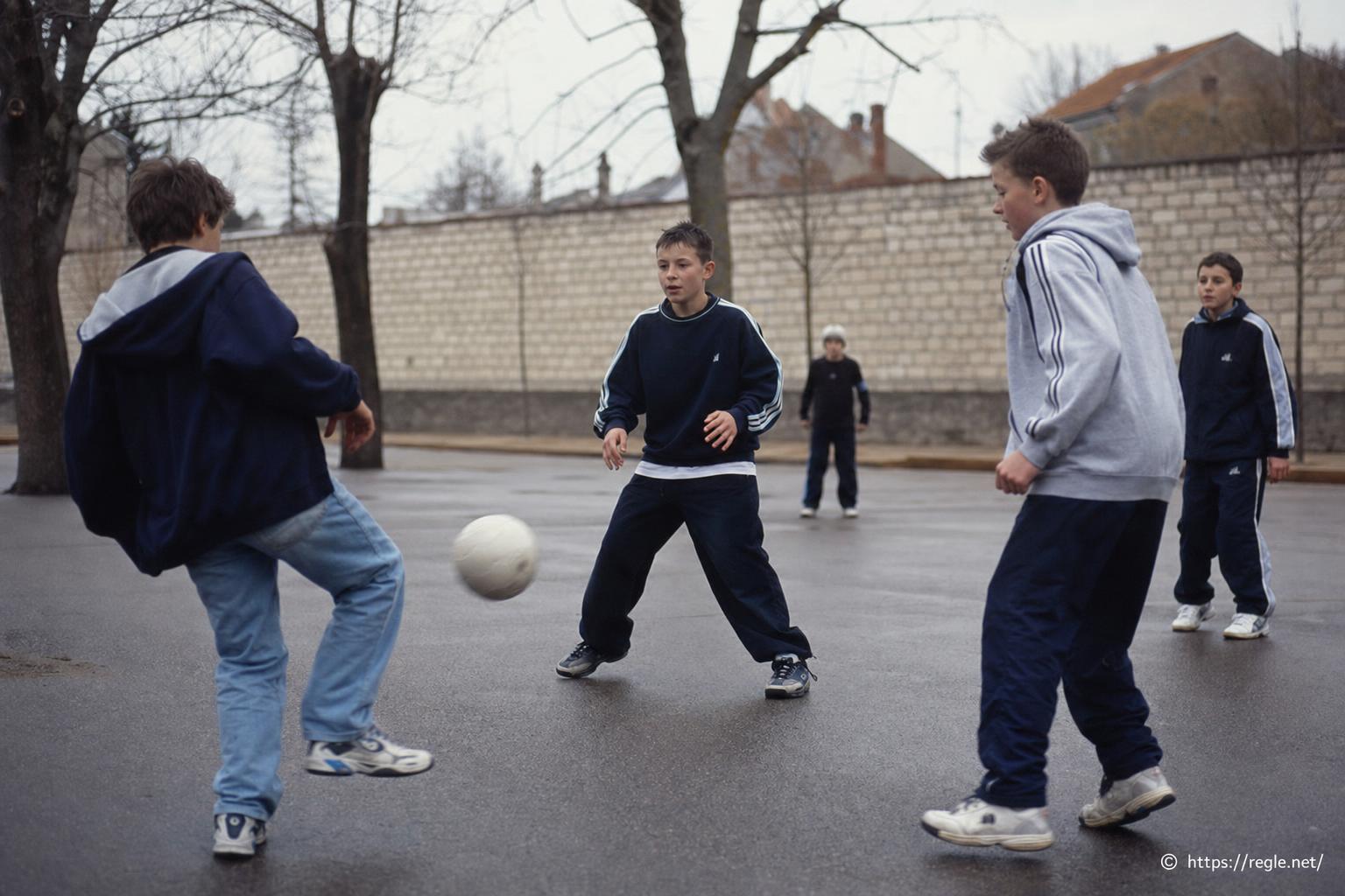 Enfants jouant au football dans la cour